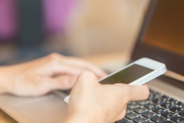 Holding ve laptop ile akıllı telefon kullanan kadınlar eller. Online iş kavramı