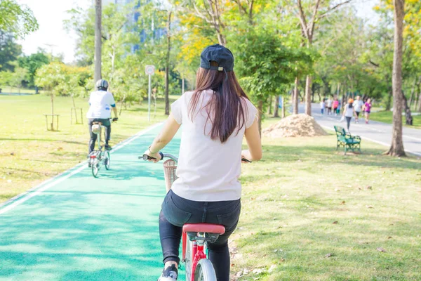 Beautiful women biker in a green city park — Stock Photo, Image