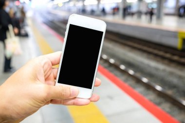 Tren stati platform cep telefonu tutan adamın elini yukarıya kapatmak