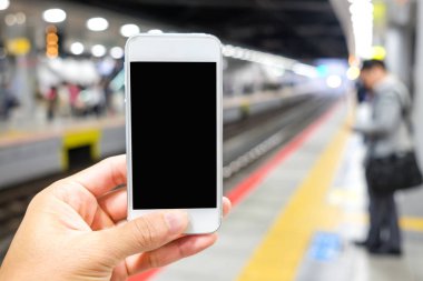 Tren stati platform cep telefonu tutan adamın elini yukarıya kapatmak