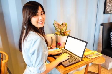 Dizüstü bilgisayar ve cep telefonu için iş s kullanarak kafede oturan kadın