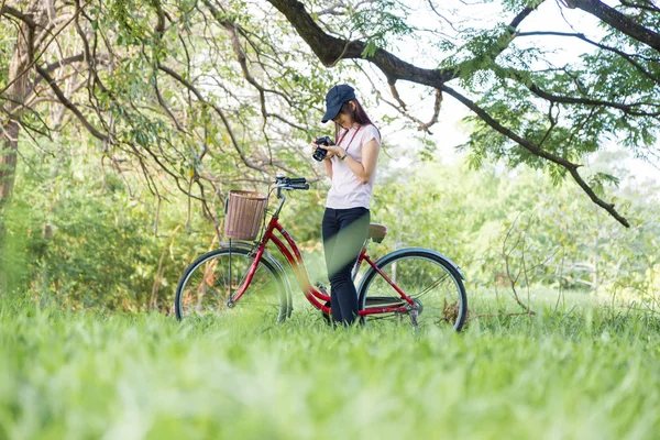Женщины и велосипед с камерой фотографируют природный городской парк — стоковое фото