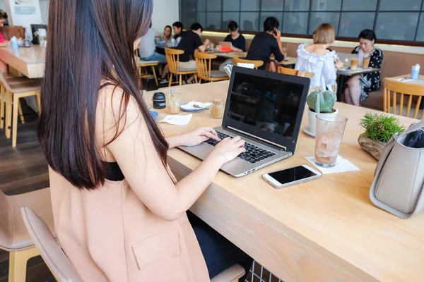 Business women use laptop in coffee shop with blur people backgr — Stock Photo, Image