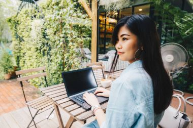 Arkadan görünüş kadınlar kafede kahve fincanı ile dizüstü bilgisayar kullanmak