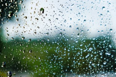 Bulanık yeşil doğa ile pencerede yağmur Damlaları 