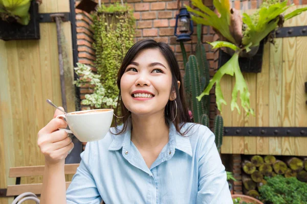 アジアの女性が白ラテ アート コーヒー カップでリラックスします。 — ストック写真