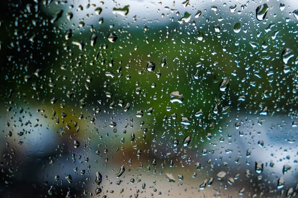 Drops of rain on window with blurred green nature — Stock Photo, Image