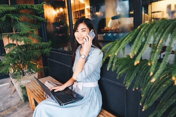 Girl calling on cellphone and use laptop computer — Stock Photo, Image