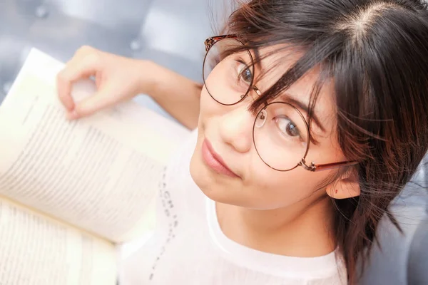 Les femmes portent des lunettes de lecture livre sur canapé confortable — Photo