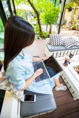 Kapıdan modern kafede dizüstü bilgisayar üzerinde çalışan erkek