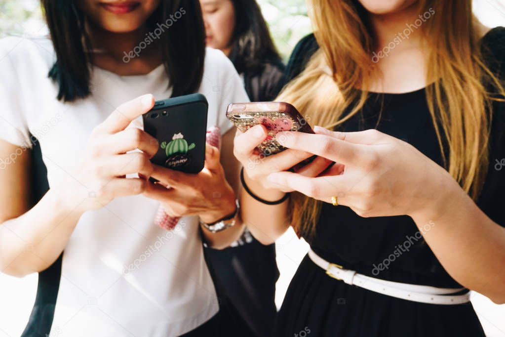 Group of women use cellphone outdoor for business contact close up on habd