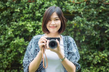 Hipster fotoğrafçı kadınlar ile yaprak yeşil zemin üzerine fotoğraf makinesi