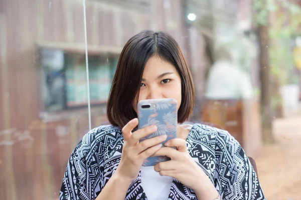 Asiático jóvenes mujeres uso celular mientras sentado en café tienda —  Fotos de Stock