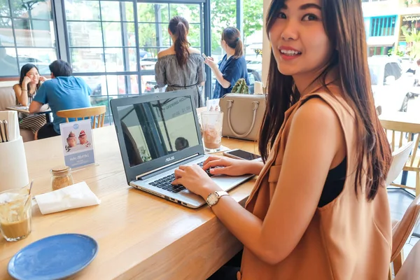 Young business asian women use laptop and cellphone in coffee shop, Business technology concept