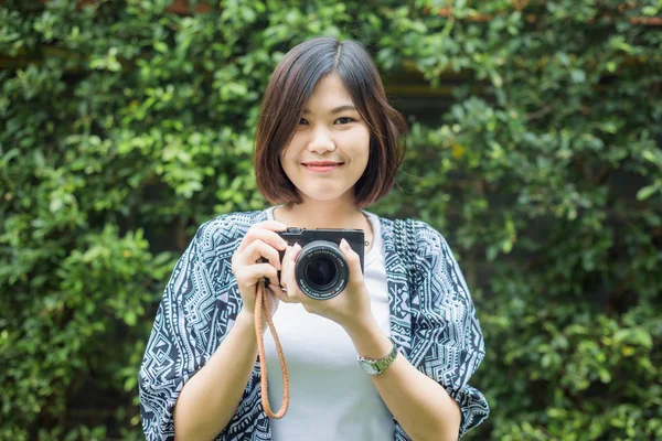 Hipster fotoğrafçı kadınlar ile yaprak yeşil zemin üzerine fotoğraf makinesi