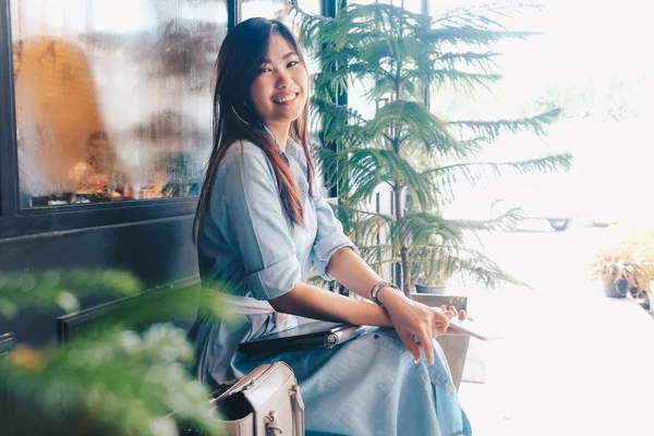 Красивые азиатки, сидящие в винтажном кафе и улыбающиеся — стоковое фото