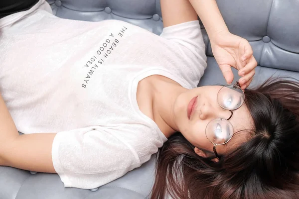 Красивые сексуальные азиатские очки женщины на винтажном диване — стоковое фото