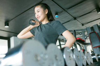 Modern bir spor salonu, fitness dışarı Wor metal dumbbells ile egzersiz kadınlar