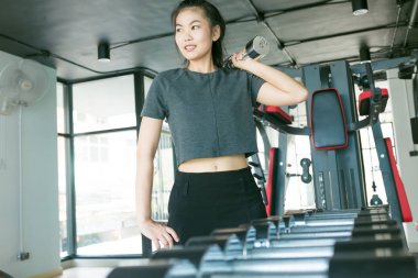 Modern bir spor salonu, fitness dışarı Wor metal dumbbells ile egzersiz kadınlar