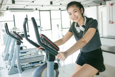 Bisiklet Bisiklet ve müzik fitness salonunda fitness kadınlar