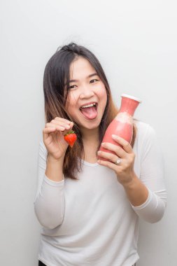 Sağlıklı kadın beyaz zemin üzerine taze meyve ile çilek güler yüzlü içme