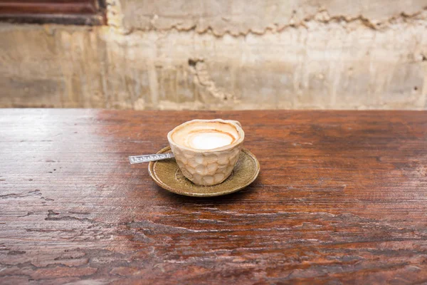 Latte art hot coffee in the stone mug on wood table — Stock Photo, Image