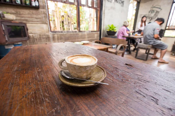 Latte art hot coffee in the stone mug on wood table, Aroma drinking