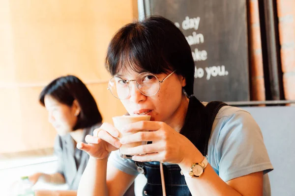 Азиатские деловые женщины пьют кофе латте в винтажном кафе — стоковое фото
