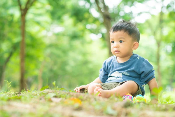Очаровательный малыш-младенец играет в зеленом парке — стоковое фото