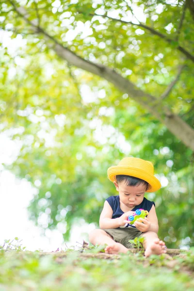 Adorable bébé tout-petit bébé garçon jouant dans un parc vert — Photo