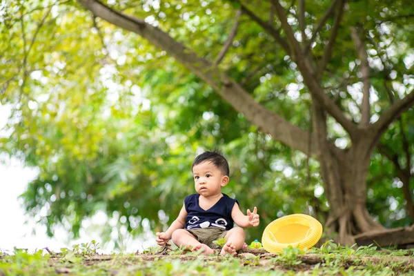 Очаровательный малыш-младенец играет в зеленом парке — стоковое фото