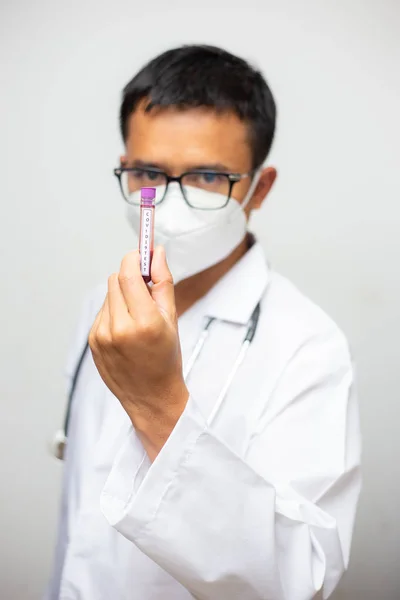白い背景にCovid19血液サンプルチューブを保持している個人的な保護スーツの医師 コロナウイルス病 Covid — ストック写真
