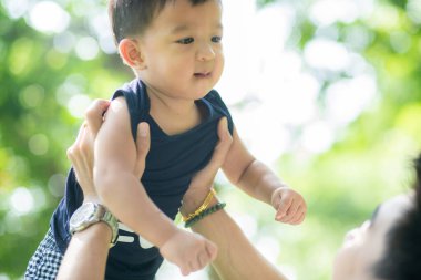 Parkta el ele tutuşurken gülümseyen bebek, doğadaki bebek.