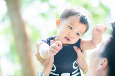 Parkta el ele tutuşurken gülümseyen bebek, doğadaki bebek.