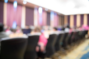 Seminer salonunda oturan bulanık insanlar iş eğitimi alıyorlar.