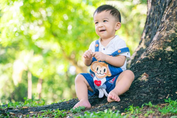 Gülümseyen Sevimli Oğlan Yeşil Parkta Oturmuş Doğada Oyuncak Bebekle Oynuyor — Stok fotoğraf