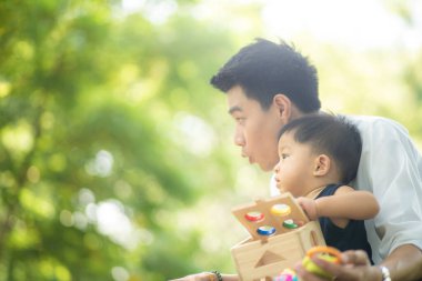 Babası şehir parkında çalıştıktan sonra oğluyla oynuyor, babası da oğlanla.