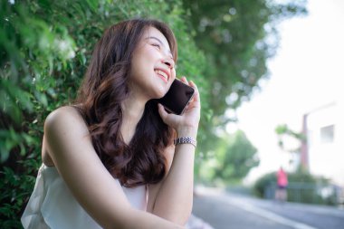 Şehir parkında cep telefonundan bahseden Asyalı kadınlar iş bağlantıları konsepti