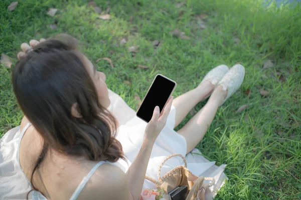Красивые Женщины Сидящие Зеленой Траве Используют Смартфон Чате — стоковое фото