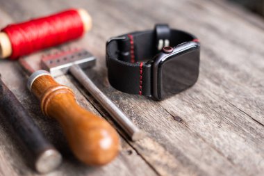 Hakiki deri saat kayışı ahşap arka planda el yapımı, işçilik