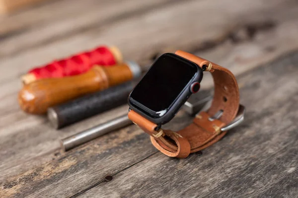 Craft working of leather watch strap on wood table