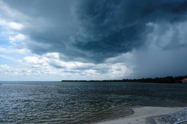 Yağmurlu bulutlardan önce deniz sahilinde gök gürültülü gök gürültülü fırtına
