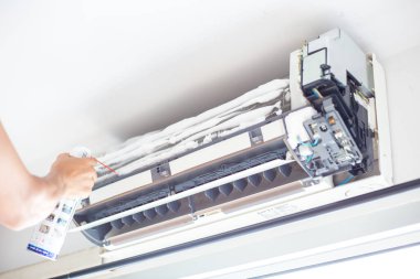 Evde çalışan koca odasında köpüklü hava temizliği yapıyor.