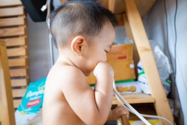 Sevimli erkek bebek gergin bir ifadeyle ısıran bebek ve ilk dişleri çıkıyor.