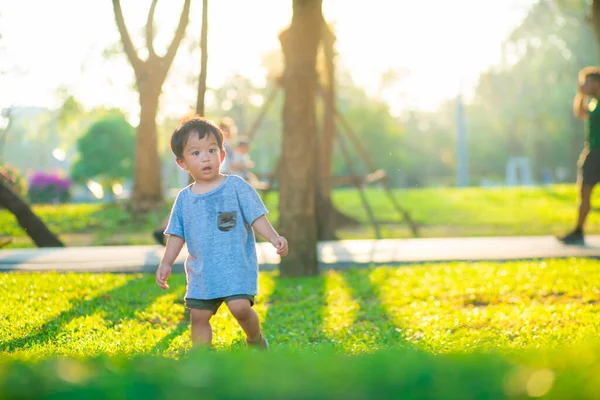 Yeşil Çimlerde Yürüyen Sevimli Asyalı Çocuk Yaz Tatilinde Gün Batımı — Stok fotoğraf