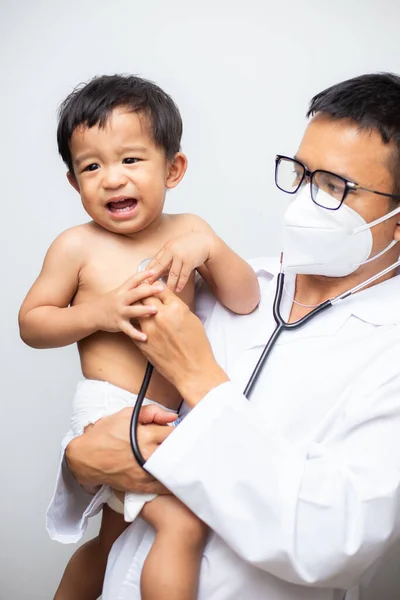 Doctor in lab cover suit mask holding baby boy Corona virus test blood in tube on white background