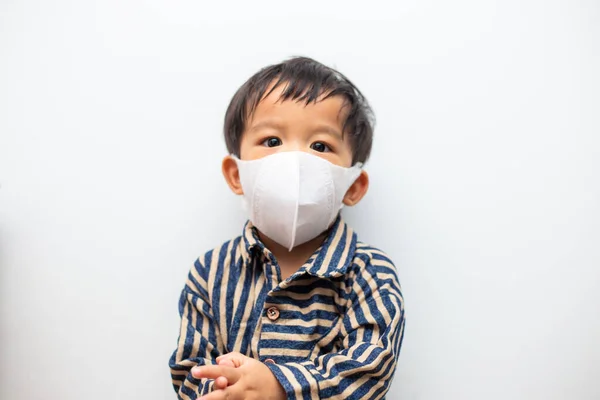 Toz maskesi takan Asyalı bebek portresi PM2.5 ve Coronavirus için ya da beyaz arka planda covid-19 bulaşıcı hastalık için koruma sağlıyor. Virüs güvenliği için yüz hijyenik maskesi