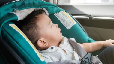 Seyahat sırasında emniyet kemerinde uzanan sevimli bebek, tasarruf arabası.