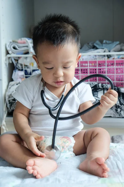 Infant baby boy playing with stethoscope doctor actor