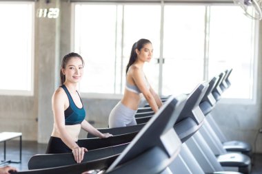 Spor salonunda koşu bandında çalışan bir grup kadın kardiyo tartısı kaybı konsepti yapıyor.